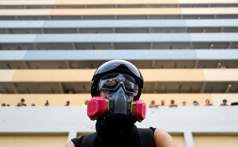 Thousands march in Hong Kong as police in black masks look on