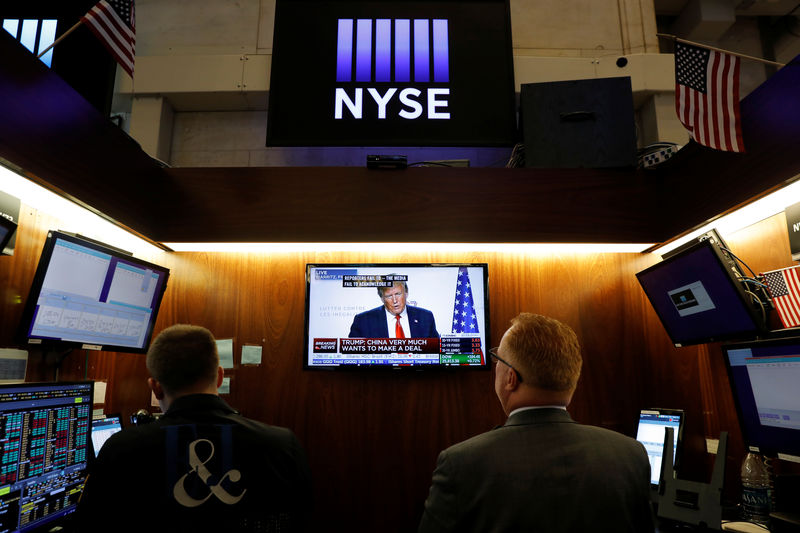 © Reuters. Traders watch monitors displaying a media conference with U.S. President Donald Trump live at the G7 summit on the trading floor at the New York Stock Exchange (NYSE) in New York City