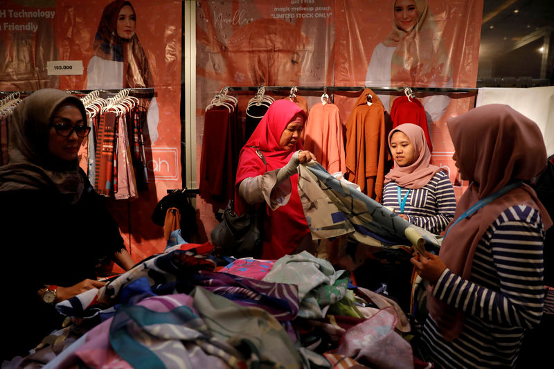 © Reuters. FILE PHOTO: Women shop for hijabs at a stall at Muslim Fashion Festival in Jakarta