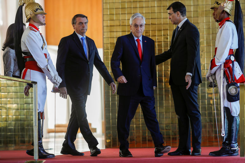 © Reuters. FOTO DE ARCHIVO: El presidente de Brasil, Jair Bolsonaro, y el mandatario de Chile, Sebastián Piñera, acuden a una conferencia de prensa en el Palacio Alvorada en Brasilia