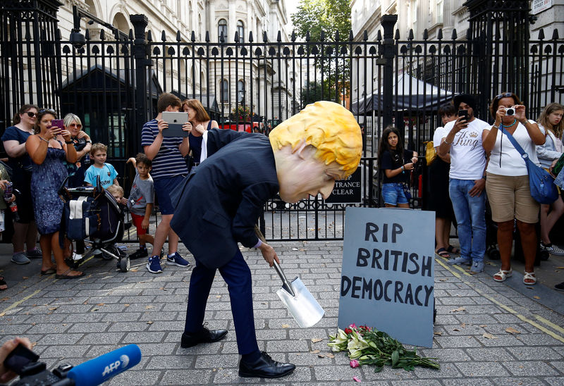 © Reuters. A man wearing a mask of Boris Johnson protests outside Downing Street in London