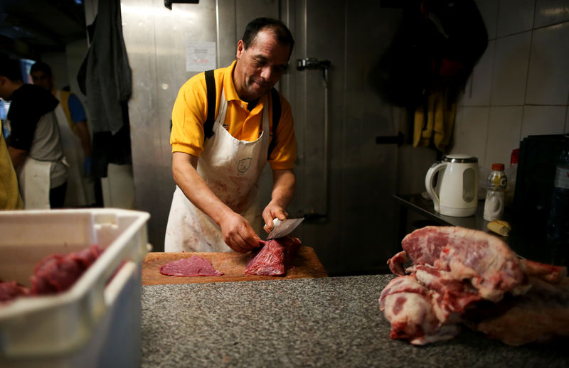 © Reuters. Açougueiro corta bifes em mercado local de Buenos Aires