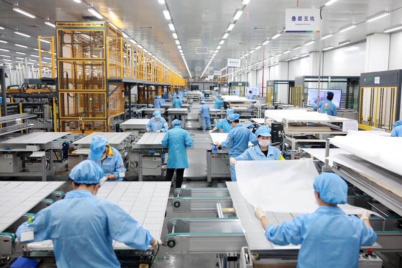 © Reuters. Employees work on photovoltaic solar panels at a factory of Risen Energy in Ningbo