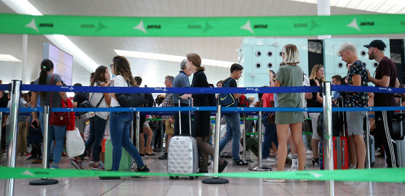 © Reuters. FILE PHOTO: People walk to security control area at Barcelona-El Prat airport