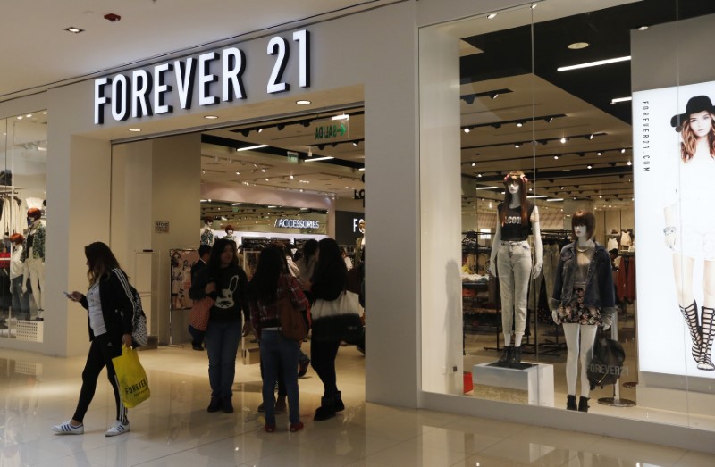 © Reuters. Customers walk and stand outside the first Forever 21 retail store in Lima, at Real Plaza Salaverry shopping mall