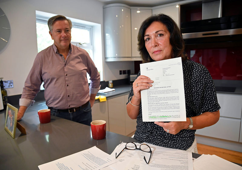 © Reuters. Anna Amato holds documentation and correspondence with The Home Office, with her husband Connell at her home in Bristol