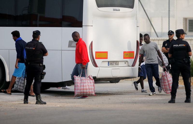 © Reuters. Migrants leave a police bus after arriving on the Spanish military ship 'Audaz' at a port in San Roque, near Algeciras