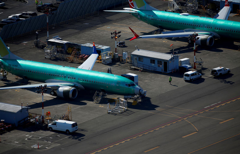 © Reuters. FILE PHOTO: A worker walks past unpainted Boeing 737 MAX aircraft parked at Renton Municipal Airport in Renton