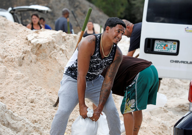© Reuters. Residentes llenan sacos de arena antes de la llegada del huracán Dorian a Kissimmee, Florida.