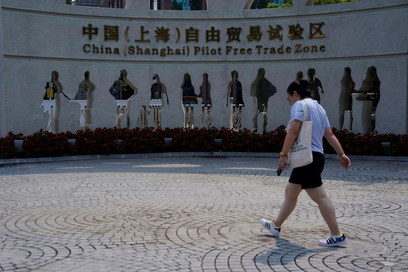 © Reuters. Una mujer camina a la entrada de la Zona de Libre Comercio de Shanghai en el distrito de Pudong, en Shanghai