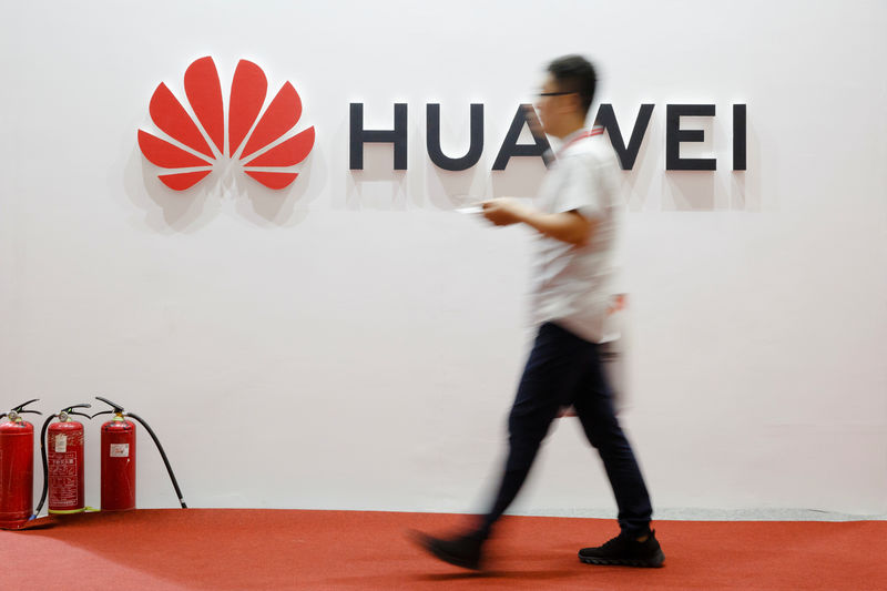 © Reuters. A man walks past a Huawei company logo at the International Consumer Electronics Expo in Beijing