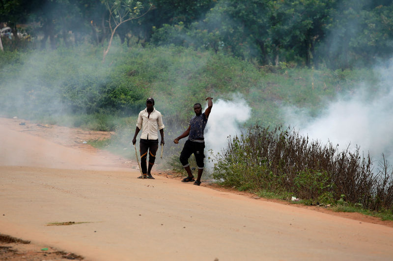 © Reuters. Protester gestures at the police after teargas was fired at them along Airport Road in Abuja