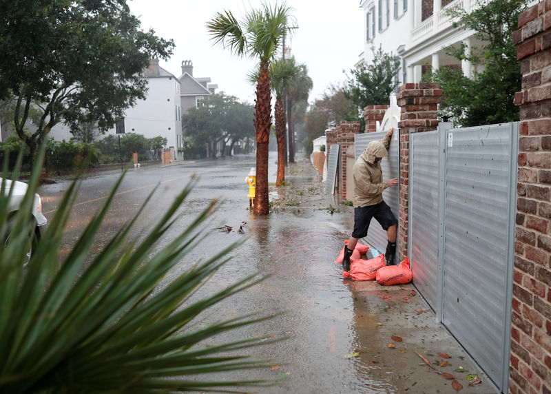 © Reuters. Brys Stephens struggles to install a metal flood gate along South Battery during Hurricane Dorian in Charleston