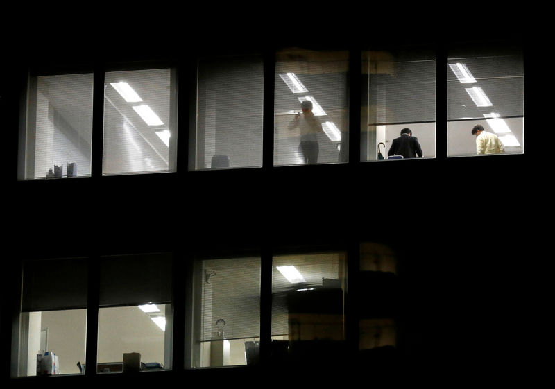 © Reuters. FILE PHOTO: Businessman looks outside at a office building in Tokyo's Shinjuku business district,