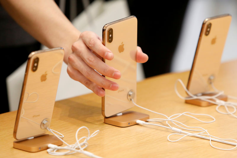 © Reuters. FILE PHOTO: People look at  iPhones at the World Trade Center Apple Store during a Black Friday sales event in Manhattan, New York City