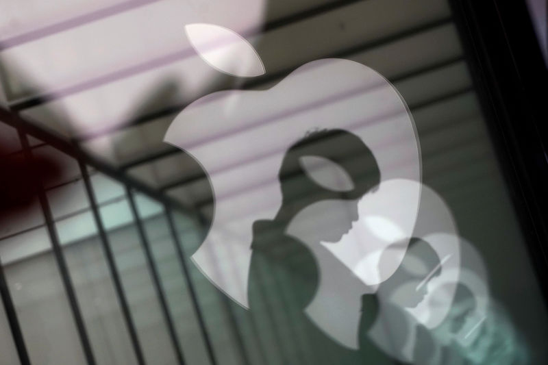 © Reuters. FILE PHOTO: Apple company logos are reflected on the glass window outside an Apple store in Shanghai