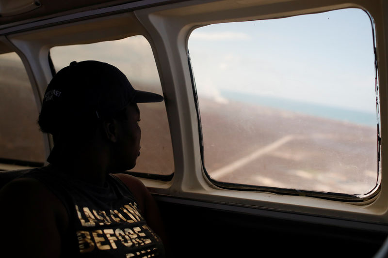 © Reuters. A woman looks down through an airplane window as the plane takes off during an evacuation operation after Hurricane Dorian hit the Abaco Islands in Marsh Harbour