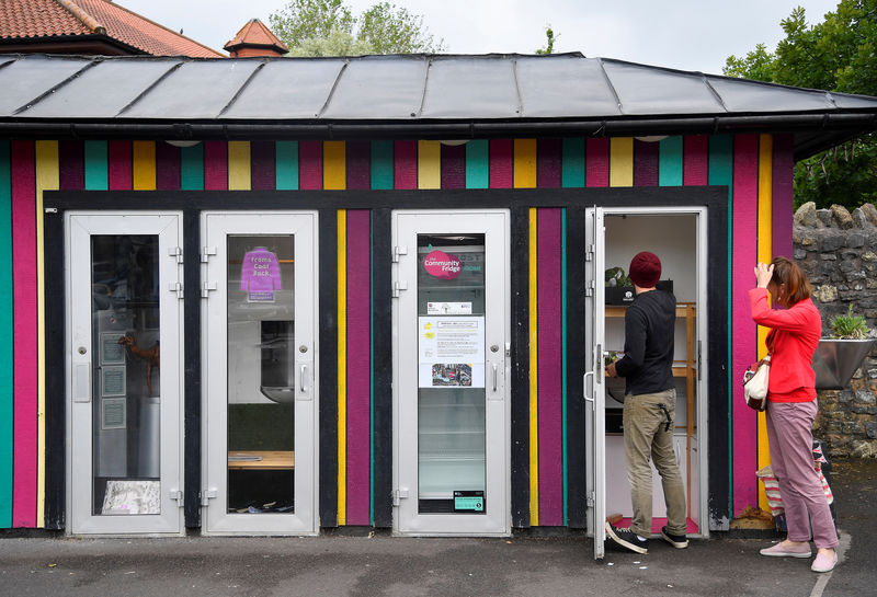 © Reuters. Locals use the Community Fridge, a place where anybody can take daily donations of food and clothing items for free, in Frome