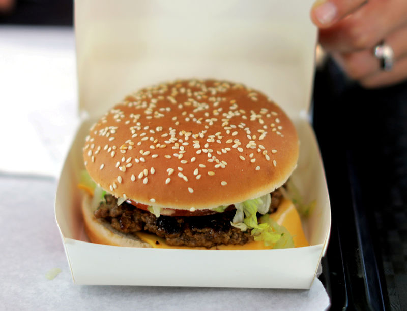 © Reuters. FILE PHOTO: An employee prepares to serve a burger at a fast food restaurant in Nice, France