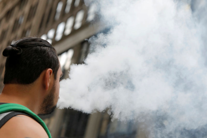 © Reuters. A man uses a vape as he walks on Broadway in New York City