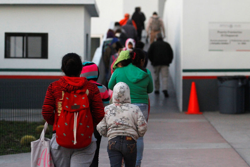 © Reuters. Immigrants from Central America and Mexican citizens queue to cross into the U.S. to apply for asylum at the new border crossing of El Chaparral in Tijuana