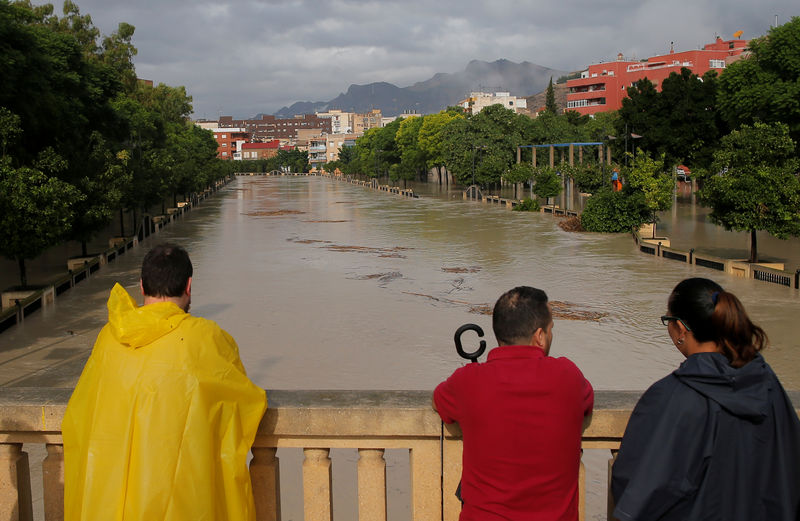 © Reuters. La gente mira el desbordamiento del río Segura cuando las lluvias torrenciales azotaron Orihuela, cerca de Murcia, España, el 13 de septiembre de 2019