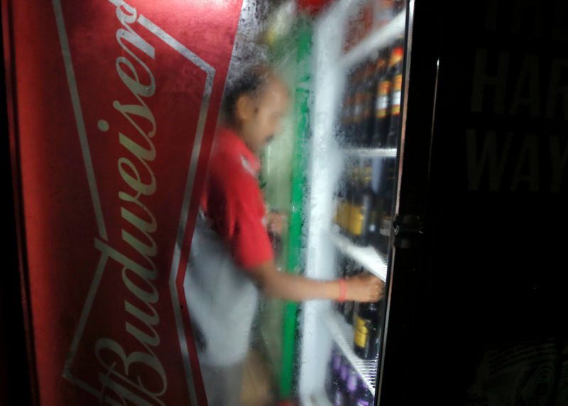 © Reuters. A worker arranges Budweiser beer bottles in a cooler at a liquor shop in Kolkata