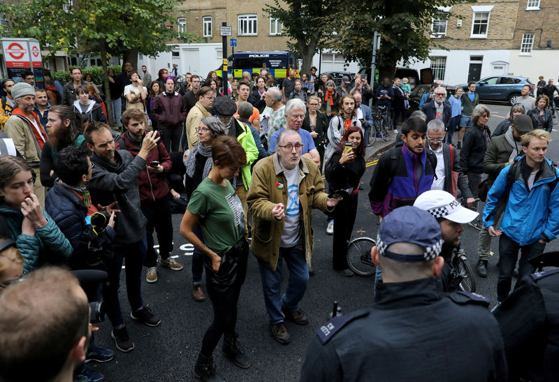 © Reuters. People are seen outside as police officers raid an Extinction Rebellion storage facility, at Lambeth County Court, in London