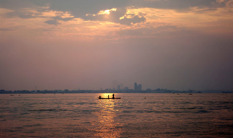 © Reuters. A wooden pirogue sails at dusk on the Congo River against the backdrop of high rises in Kinshasa