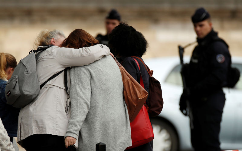 © Reuters. People hug as they leave Paris Police headquarters in Paris