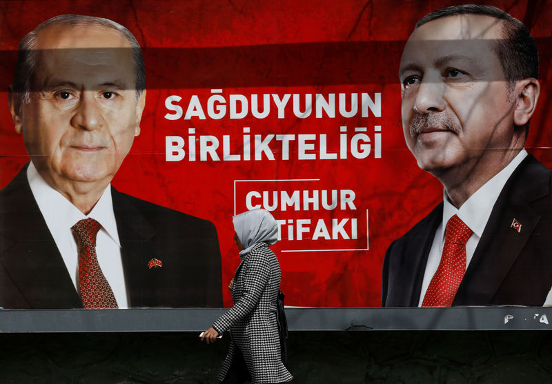 © Reuters. A woman walks past a banner for the upcoming local elections in Ankara