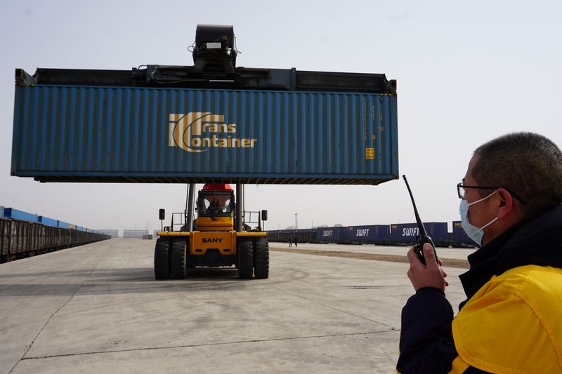 © Reuters. Workers transport a container from a China-Europe freight train that departed from Russia's Omsk, at a cargo terminal in Ulanqab