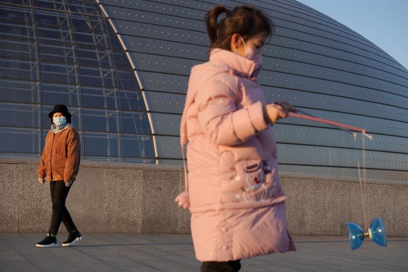 © Reuters. Girl wearing a face mask plays with a diabolo near the National Centre for the Performing Arts, following an outbreak of the novel coronavirus in the country, in Beijing