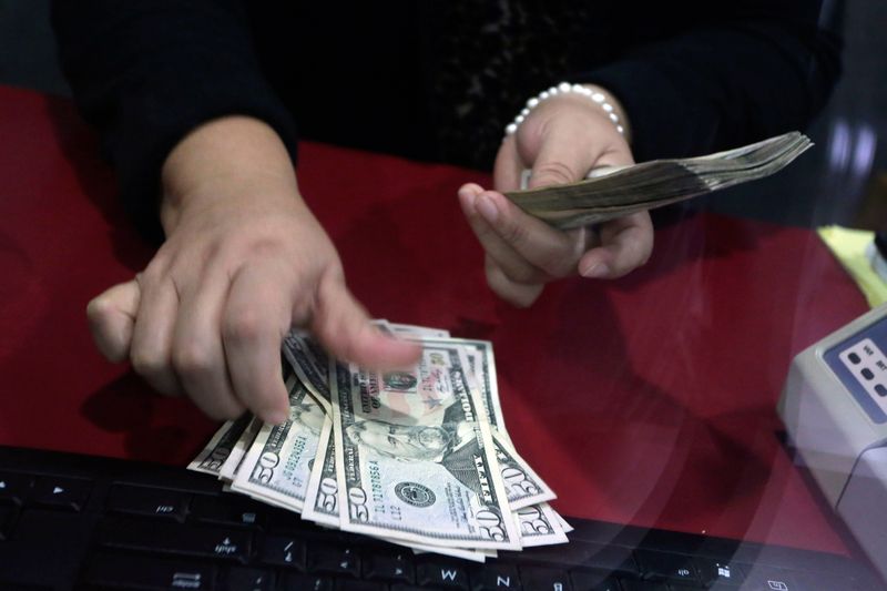 © Reuters. Employee counts U.S. dollar banknotes at a foreign exchange house in Monterrey