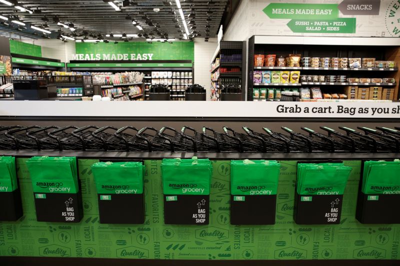 © Reuters. Shopping bags and carts are pictured in the foreground during a tour of an Amazon checkout-free, large format grocery store in Seattle