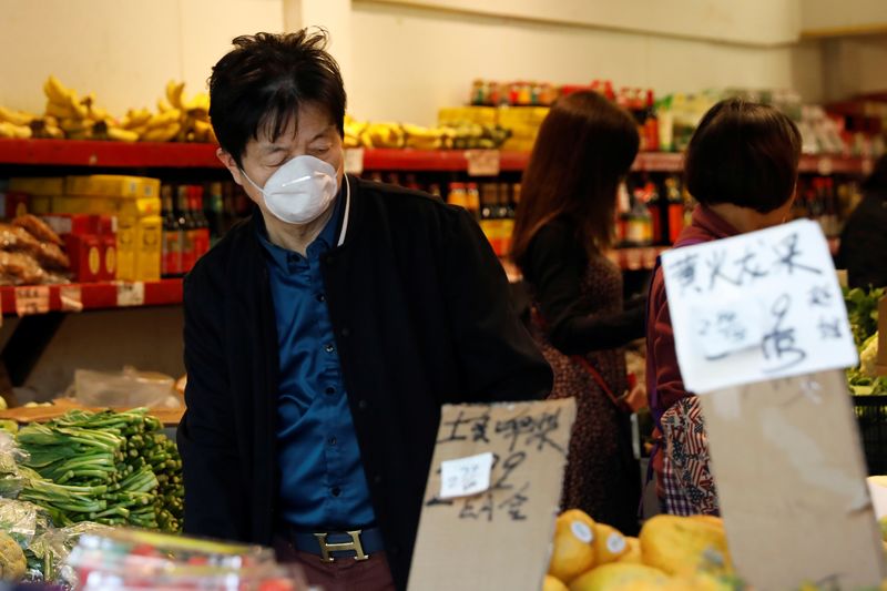 © Reuters. A man wears a face mask shopping at a market in the Chinatown section of San Francisco, California