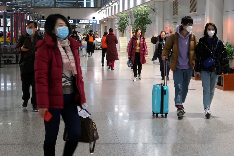 © Reuters. FILE PHOTO: Passengers wearing masks are seen at the terminal hall of the Beijing Capital International Airport