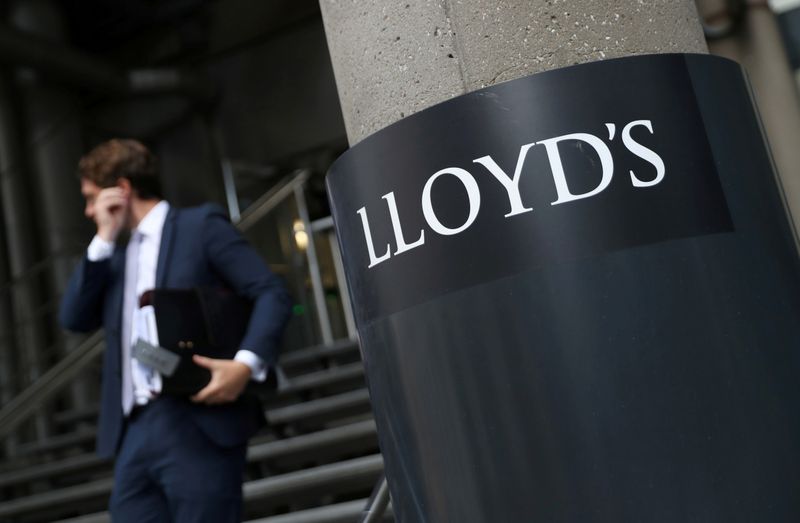 © Reuters. FILE PHOTO: A man walks out of Lloyds of London's headquarters in the City of London