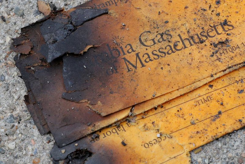 © Reuters. FILE PHOTO: FILE PHOTO: A burnt Columbia Gas of Massachusetts envelope sits on the sidewalk outside a home burned during a series of gas explosions in Lawrence