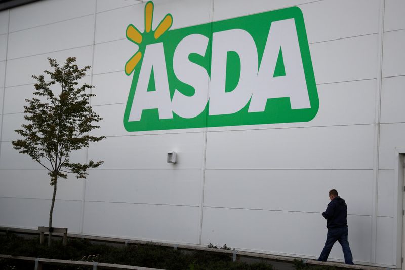 © Reuters. FILE PHOTO: A man walks past a branch of ASDA in Altrincham.