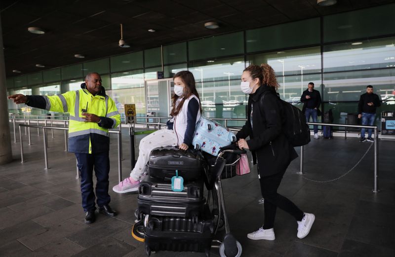 © Reuters. Foto de una mujer y una niña llegando al aeropuerto Barcelona-El Prat desde China