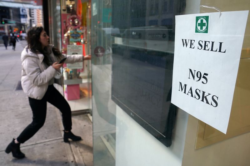 © Reuters. A woman walks into a pharmacy to purchase N95 face masks in advance of the potential coronavirus outbreak in the Manhattan borough of New York City