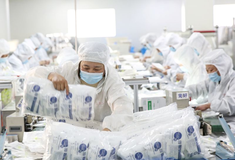 © Reuters. Employees work on a medical supply production line at a factory in Huaian