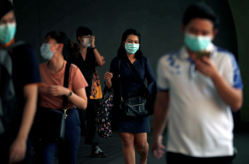 © Reuters. People wear masks as a preventive measure against the coronavirus outbreak, in Bangkok