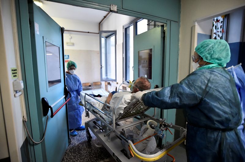&copy; Reuters. Operatori sanitari trasportano un paziente in barella presso l&apos;ospedale Cernusco sul Naviglio a Milano