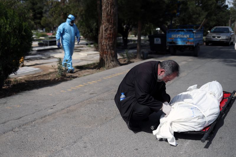&copy; Reuters. Parente durante enterro de vítima do Covid-19 em Teerã