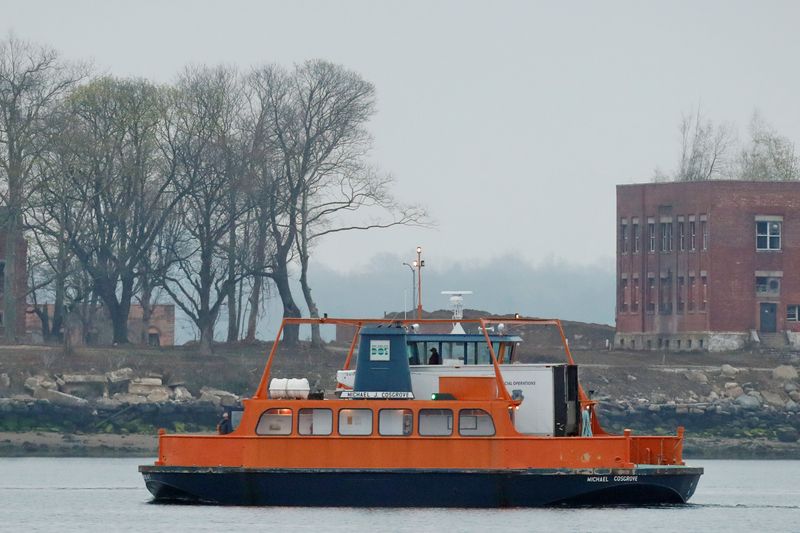 &copy; Reuters. A motorman drives a ferry carrying a refrigerated truck full of bodies to Hart Island for burial, where the department of corrections is dealing with more burials overall, amid the coronavirus disease (COVID-19) outbreak in New York City