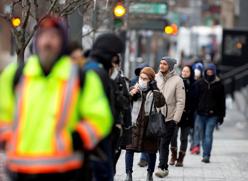 &copy; Reuters. A woman adjusts her mask while she waits in line as the city&apos;s public health unit holds a walk-in clinic testing for coronavirus disease (COVID-19) in Montreal