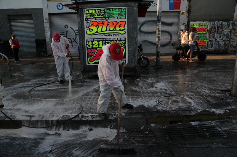 © Reuters. Trabalhadores desinfetam rua de Santiago, no Chile, em meio à pandemia de coronavírus