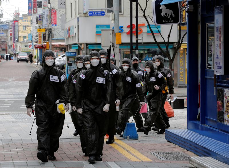 &copy; Reuters. FILE PHOTO: South Korean soldiers in protective gear make their way while they disinfect buildings downtown, following the rise in confirmed cases of coronavirus disease (COVID-19) in Daegu